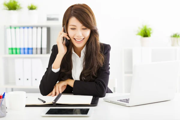 Happy business woman talking on the phone in office — Stock Photo, Image