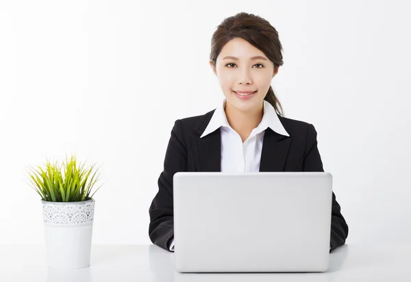 Jonge zakenvrouw werken met laptop en groene plant — Stockfoto