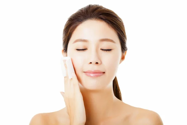 Mooie jonge vrouw reinigen van haar gezicht met katoen — Stockfoto