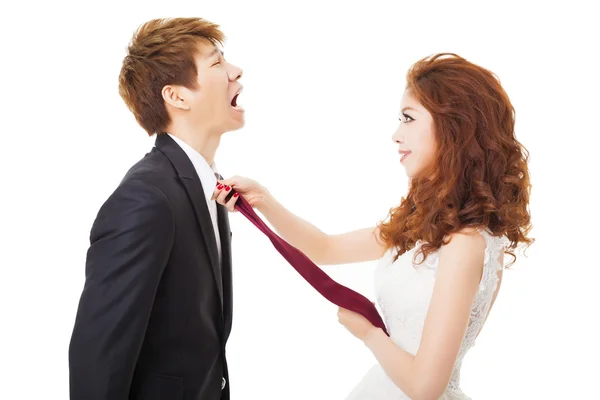 Bride pulling on groom tie for control concept — Stock Photo, Image