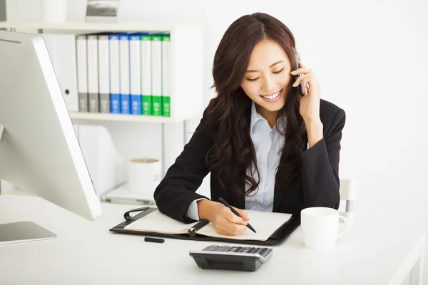 Glückliche junge Geschäftsfrau, die im Büro arbeitet — Stockfoto