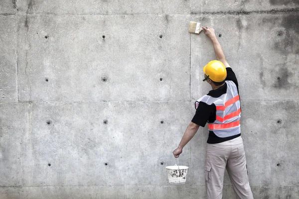 Pintor trabalhando na parede de concreto velho — Fotografia de Stock