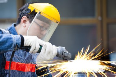 Değirmeni makine kesme metal fabrikasında işçi