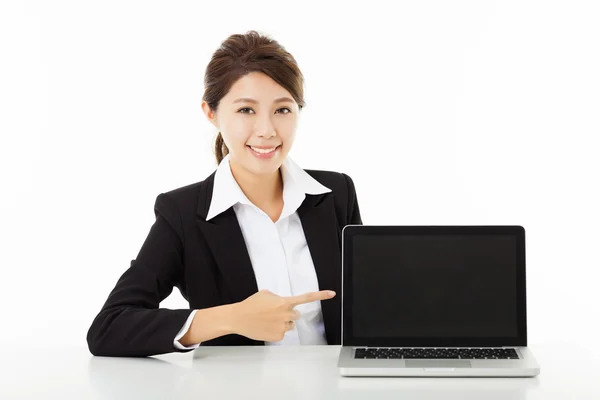 Улыбающаяся молодая деловая женщина, показывающая и указывающая на ноутбук — стоковое фото