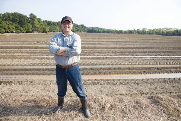 Азіатський фермер стоїть на фермерських землях — стокове фото