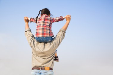 Onun kızı ile mavi gökyüzü backgrou omuzlarında taşıyan baba