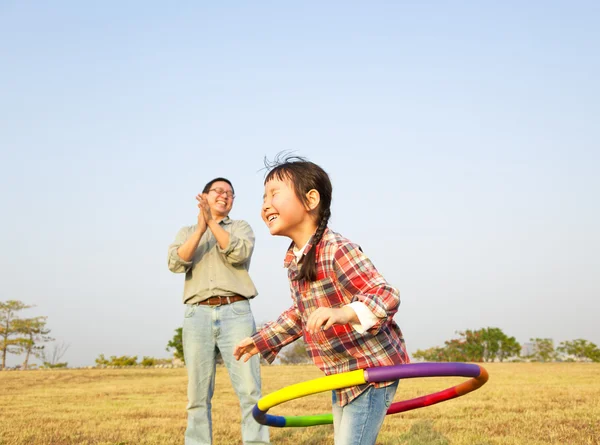 Menina feliz jogando hula hoops ao ar livre — Fotografia de Stock