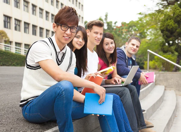 Szczęśliwy grupa młodych studentów siedzi na schody — Zdjęcie stockowe
