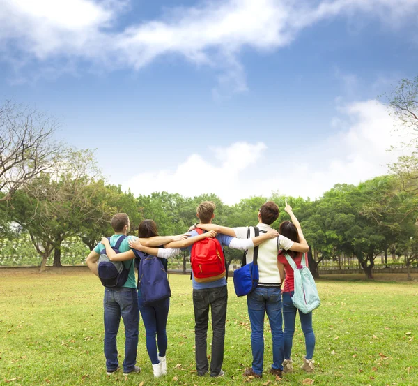 Jovem grupo feliz de estudantes observando o céu — Fotografia de Stock