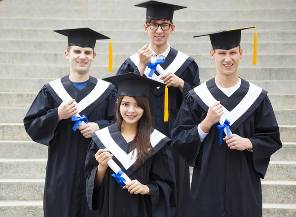 Genç öğrenciler mezuniyet önlük Üniversitesi kampüsünde — Stok fotoğraf