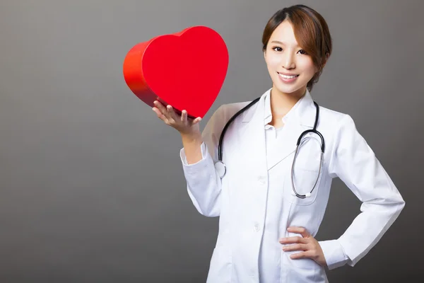 Uśmiechający się Azji kobieta lekarz z sercem — Zdjęcie stockowe