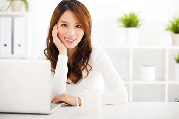 Lachende jonge Aziatische vrouw met laptop — Stockfoto