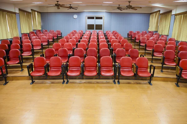 Inre av Tom konferenssal med röda stolar — Stockfoto