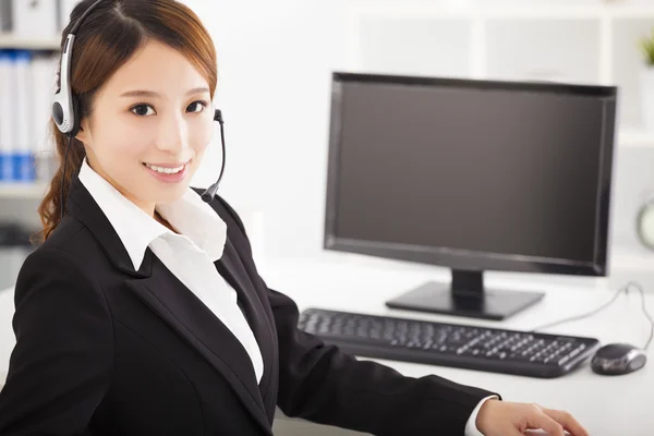 Joven hermosa mujer de negocios con auriculares en la oficina —  Fotos de Stock