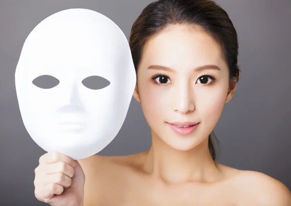Mladá žena držící bílou masku pro lékařské krásy koncept — Stock fotografie