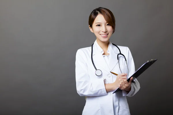 Médecin femme souriante avec presse-papiers — Photo