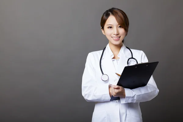 Улыбающаяся женщина-врач с планшетом — стоковое фото