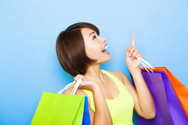 Mujer joven sosteniendo bolsas de compras y mirando hacia arriba —  Fotos de Stock