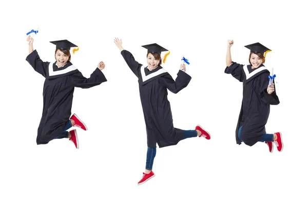 Estudante feliz em roupão de pós-graduação pulando contra costas brancas — Fotografia de Stock