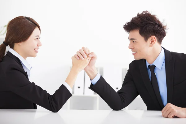 Business man and woman arm wrestling on desk in office — Stock Photo, Image