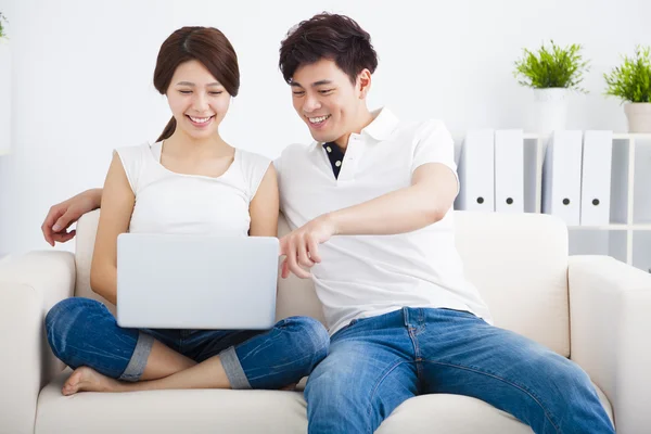 Азиатская пара на диване с ноутбуком — стоковое фото