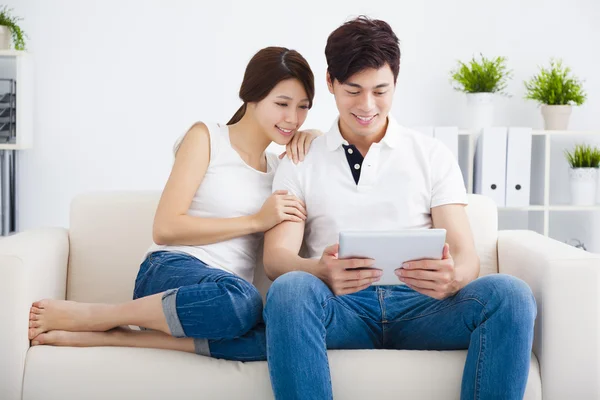 Ασιατικές ζευγάρι στον καναπέ με τον υπολογιστή tablet — Φωτογραφία Αρχείου