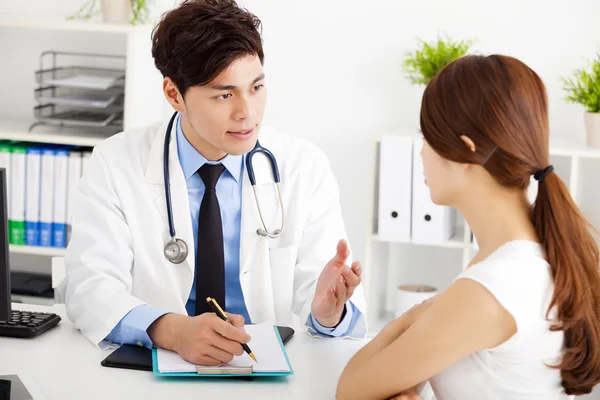 Doctor hablando con paciente femenina en el consultorio —  Fotos de Stock