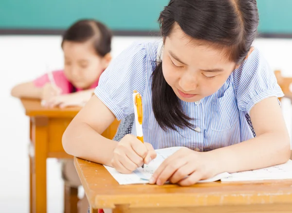 Niños en el aula con la pluma en la mano — Foto de Stock