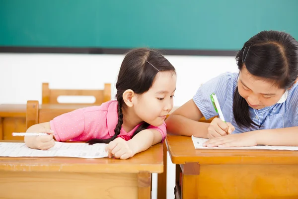 Malá dívka student snaží podvádět v testu ve třídě — Stock fotografie