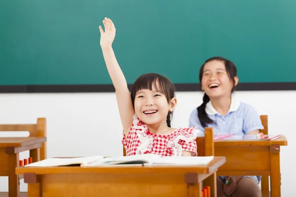 Bambini felici della scuola alzato le mani in classe — Foto Stock