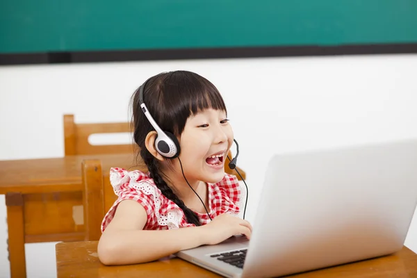 Menina feliz aprendendo computador em sala de aula — Fotografia de Stock