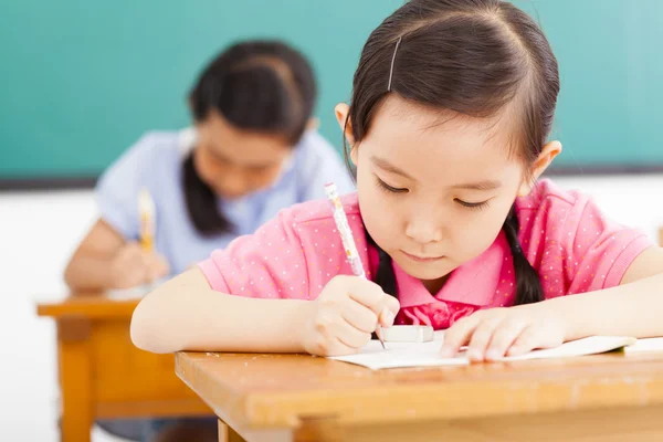 Kinderen in de klas met pen in de hand Rechtenvrije Stockfoto's