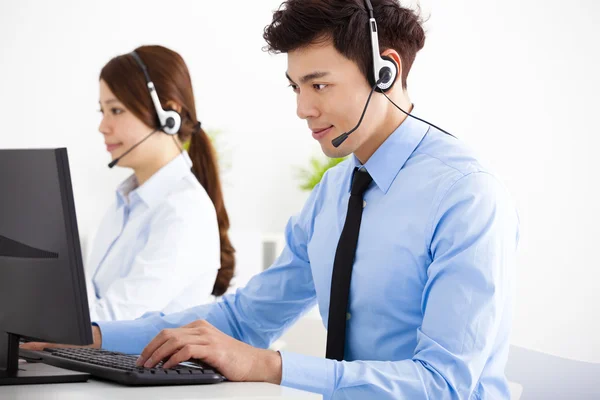 Homme d'affaires et femme avec casque travaillant dans le bureau — Photo