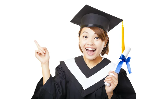 Feliz joven mujer graduándose sosteniendo diploma y señalando — Foto de Stock