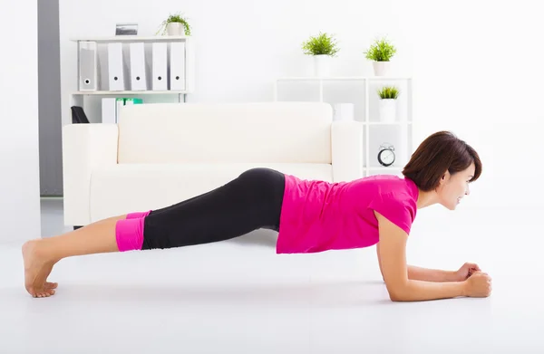 Beautiful young woman stretching on the floor — Stock Photo, Image