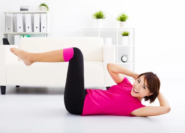 Beautiful young woman stretching on the floor — Stock Photo, Image
