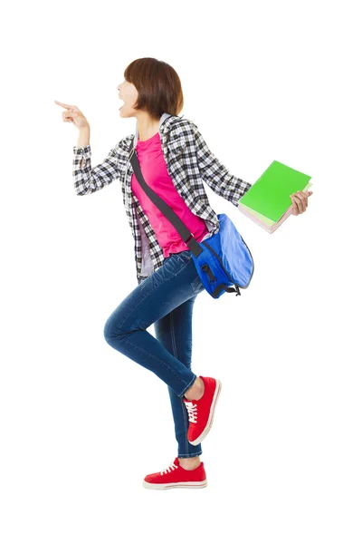 Young happy student holding books and showing something — Stock Photo, Image