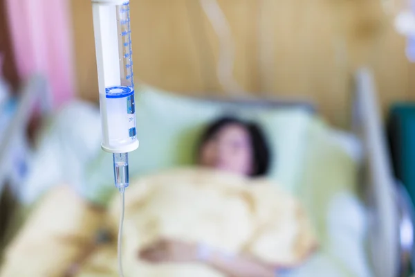 生理食塩水の点滴とベッドの上の患者 — ストック写真