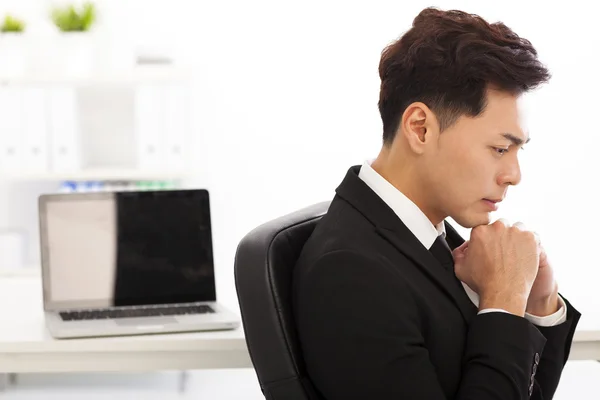 Jeune homme d'affaires pensant dans le bureau — Photo