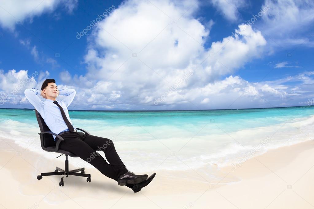 relaxed Young businessman sitting in  chair with beach backgrou