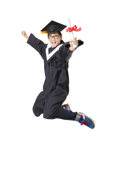 Счастливая студентка в выпускном халате прыгает на белом фоне — стоковое фото