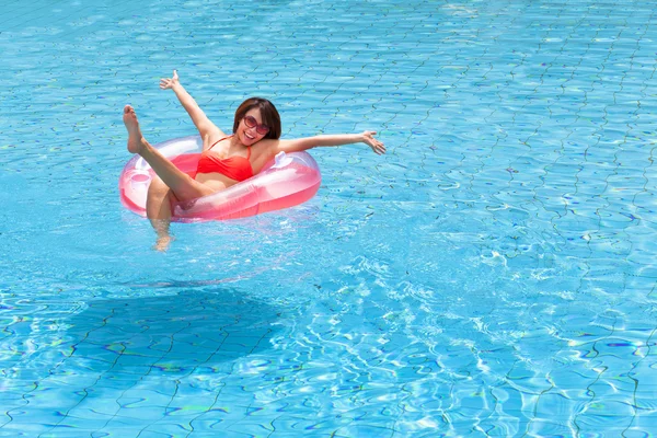 Glückliche junge Frau entspannt sich im Schwimmbad — Stockfoto