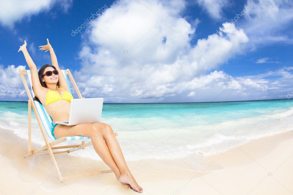 happy woman with  laptop on the tropical beach