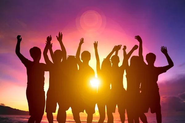 Happy young group dancing on the beach with summer sunset — Stock Photo, Image