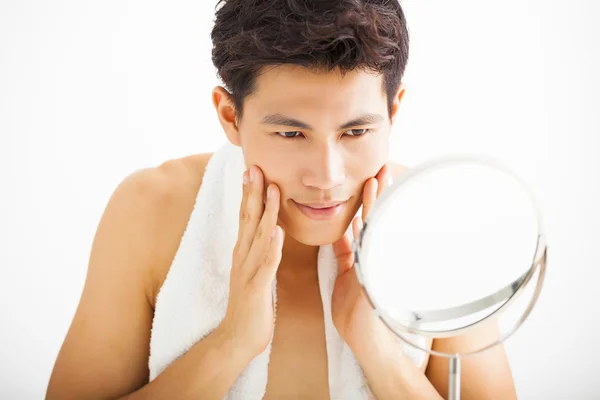 Młody człowiek dotykając jego gładkiej twarzy po goleniu — Zdjęcie stockowe
