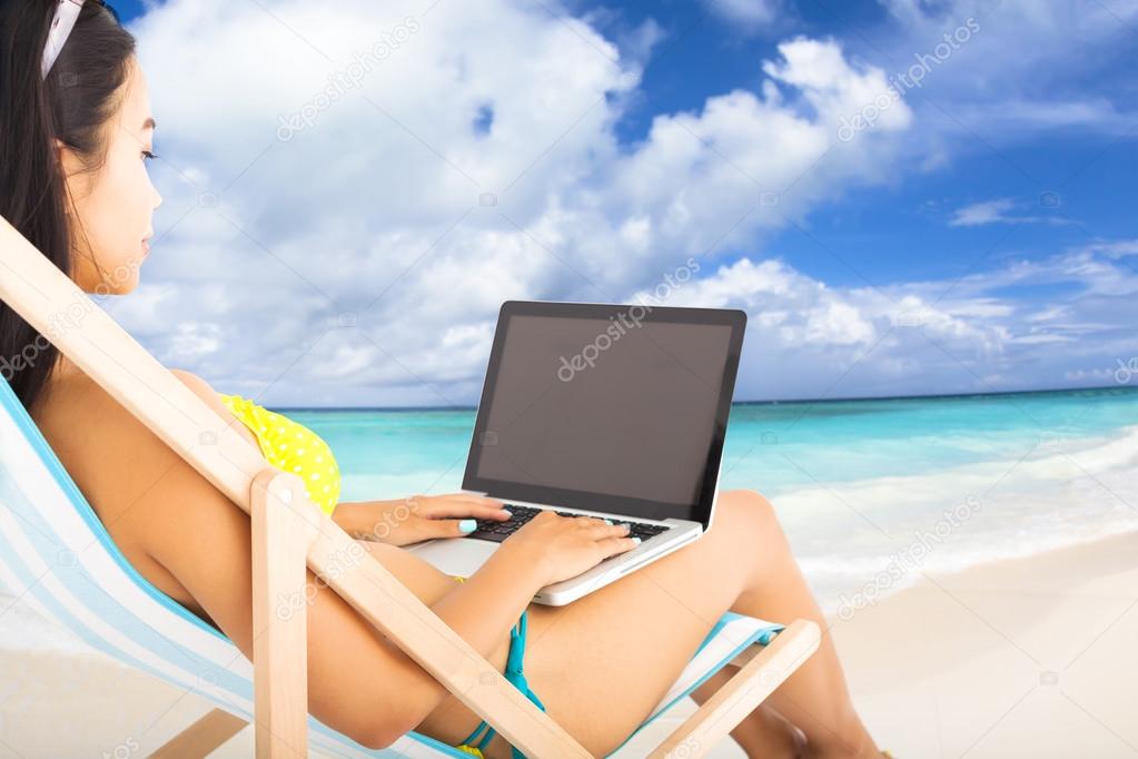 happy woman with  laptop on the tropical beach