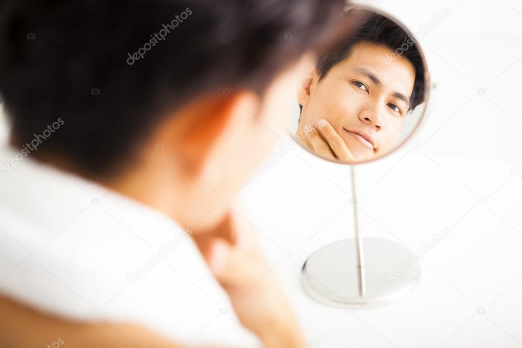 Young  man touching his smooth face after shaving