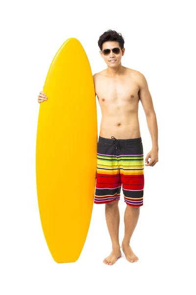 Молодой человек в полный рост держит доску для серфинга — стоковое фото