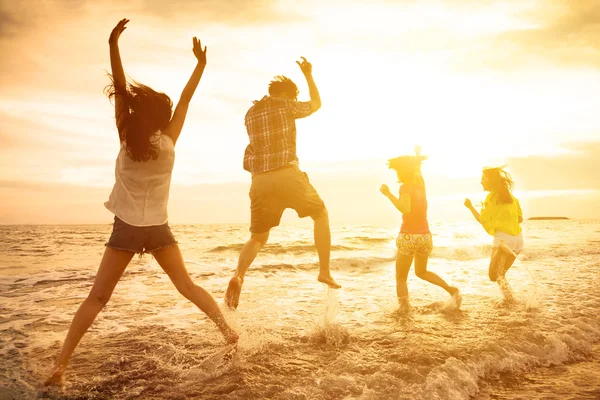 Grupo de jóvenes felices bailando en la playa — Foto de Stock