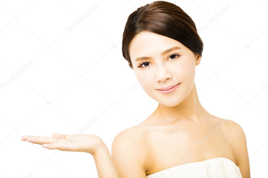 Beautiful young woman showing beauty product empty  space on  hand